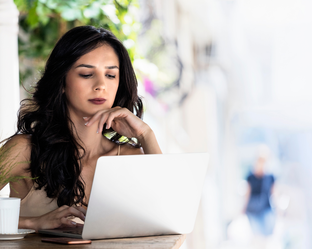 a woman sitting at a table with a laptop