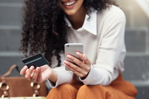 Achats en ligne, carte de crédit et femme sur smartphone en ville avec téléphone et carte bancaire à la main. Fille sur internet faisant du shopping, du commerce électronique et des achats au détail. Femme d'affaires effectuant des opérations bancaires en ligne