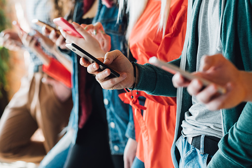 Génération du millénaire. Gros plan coloré de jeunes gens tenant des smartphones. Appareils modernes. Progrès technologique.