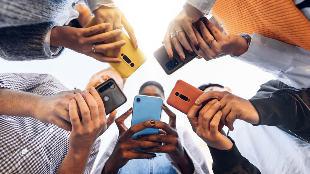 Adolescents en cercle tenant des téléphones mobiles intelligents - Jeunes multiculturels utilisant des téléphones portables à l'extérieur - Adolescents accros au nouveau concept technologique