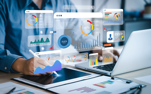 Un analyste utilise un ordinateur et un tableau de bord pour l'analyse des données commerciales et un système de gestion des données avec des indicateurs de performance clés et des mesures connectées à la base de données pour la technologie, la finance, les opérations, les ventes et le marketing.