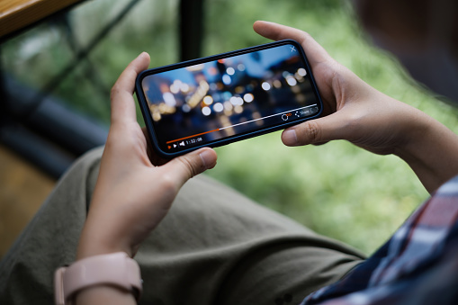 Pendant la quarantaine, une femme regarde la diffusion en direct d'une application sur son smartphone.