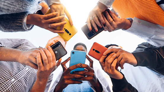 Adolescents en cercle tenant des téléphones portables intelligents - Jeunes multiculturels utilisant des téléphones portables à l'extérieur - Adolescents accros aux nouvelles technologies