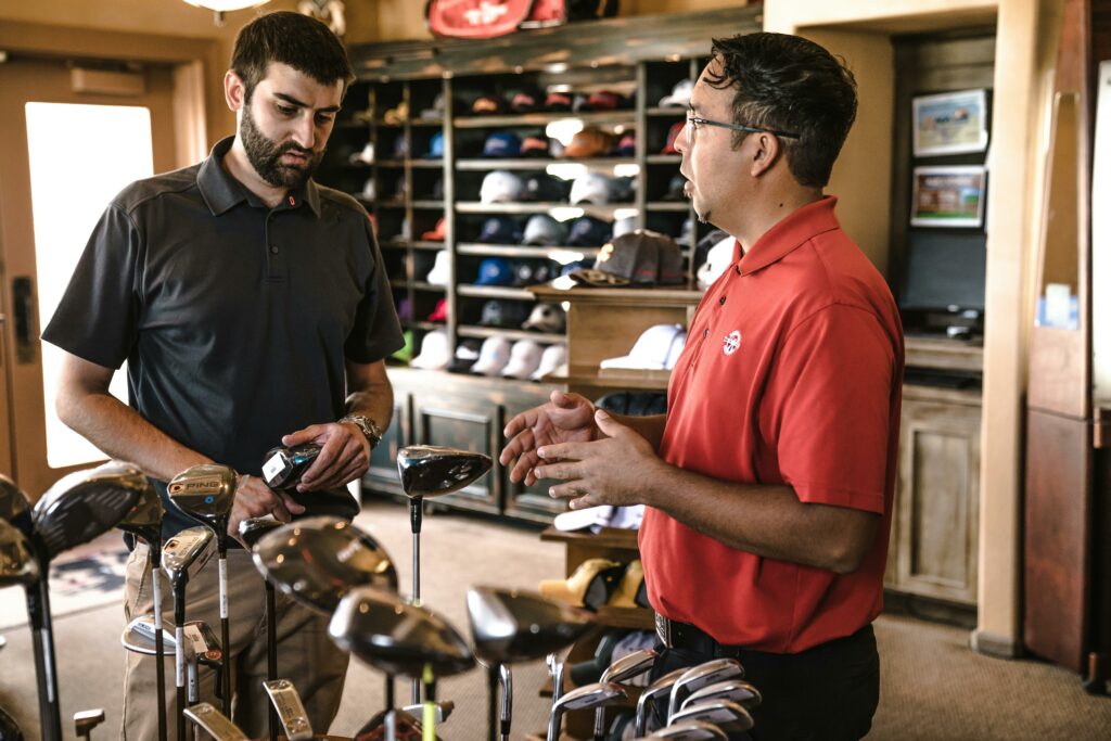 a group of men looking at golf clubs