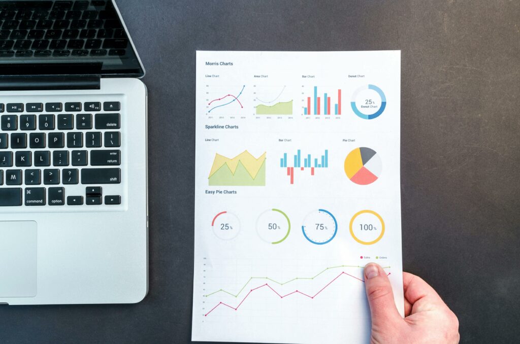 a hand pointing at a paper with graphs and charts