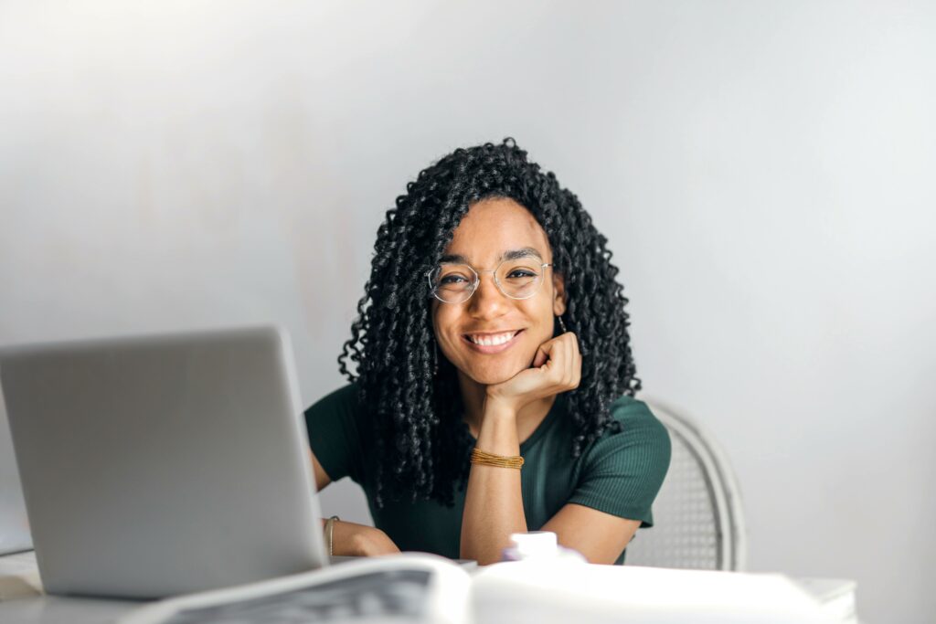 a woman smiling at a laptop