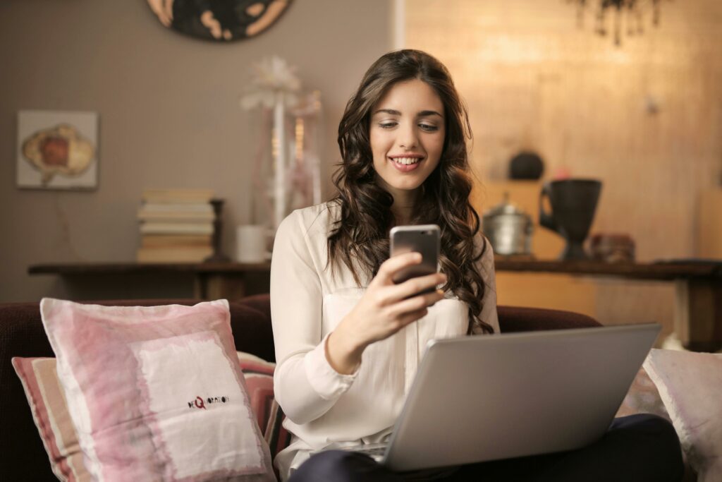 a woman sitting on a couch looking at a phone
