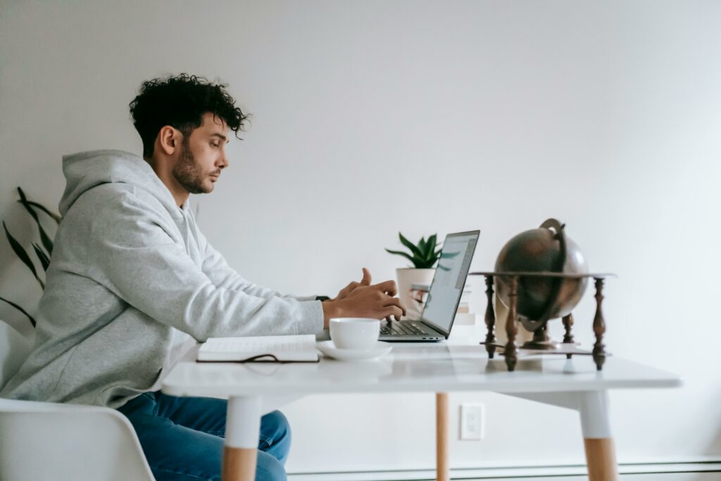 a man sitting at a table using a laptop