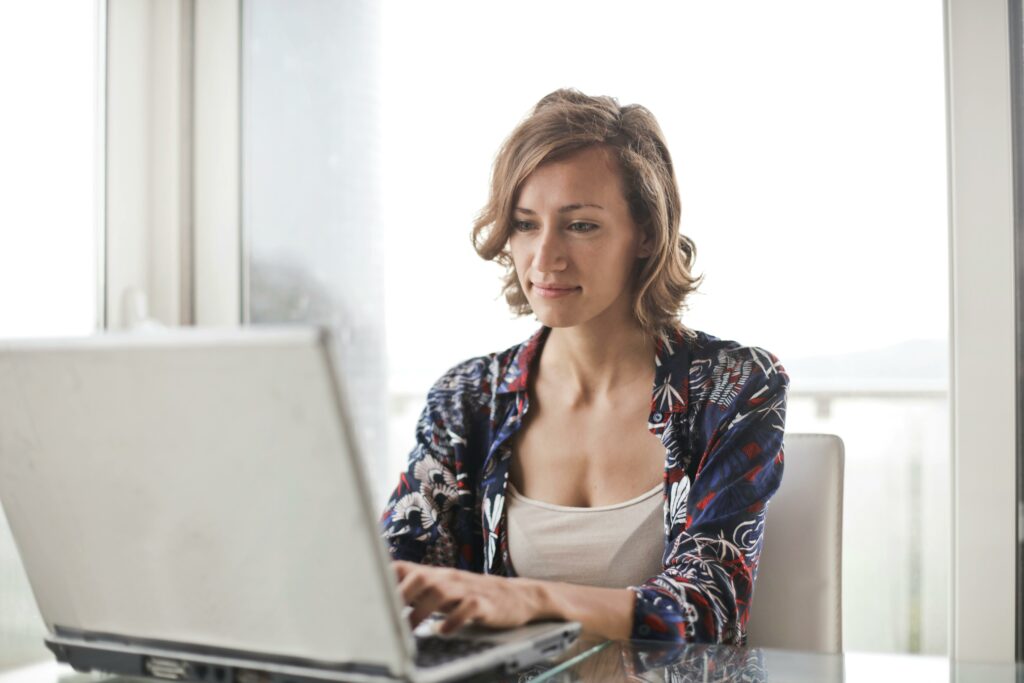 a woman sitting at a desk using a laptop