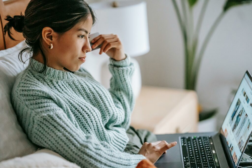 a woman sitting on a couch using a laptop