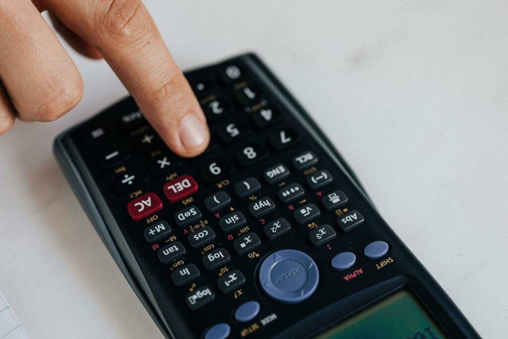 a finger pressing a calculator