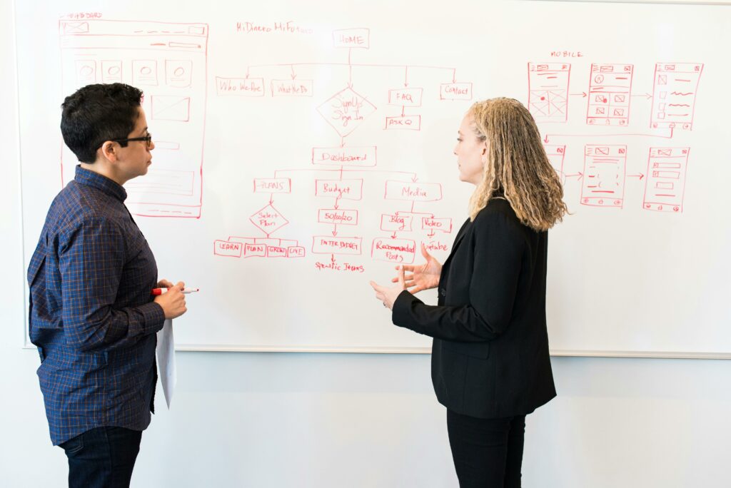 a man and woman looking at a whiteboard