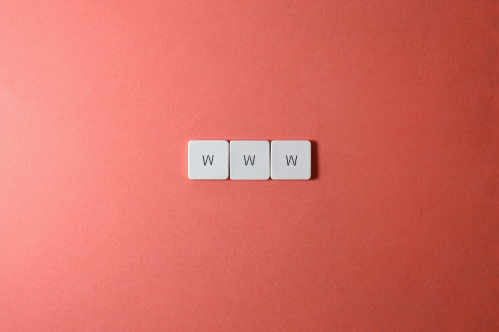 a group of white square tiles with black letters www on a pink background