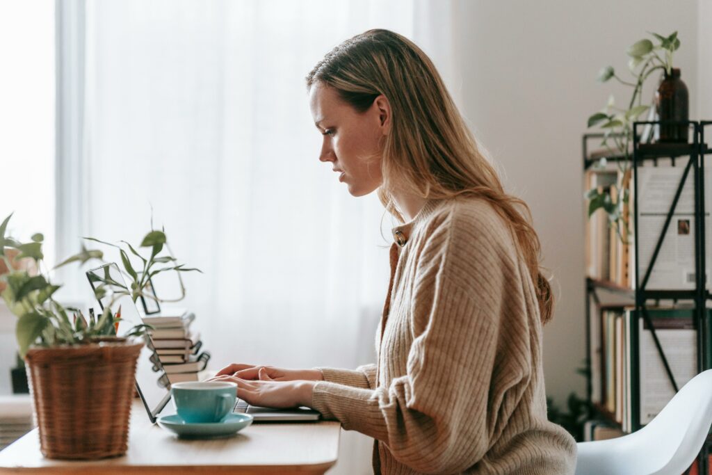 a woman sitting at a desk using a laptop