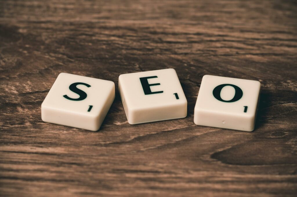 a group of white tiles with black letters SEO on a wooden surface