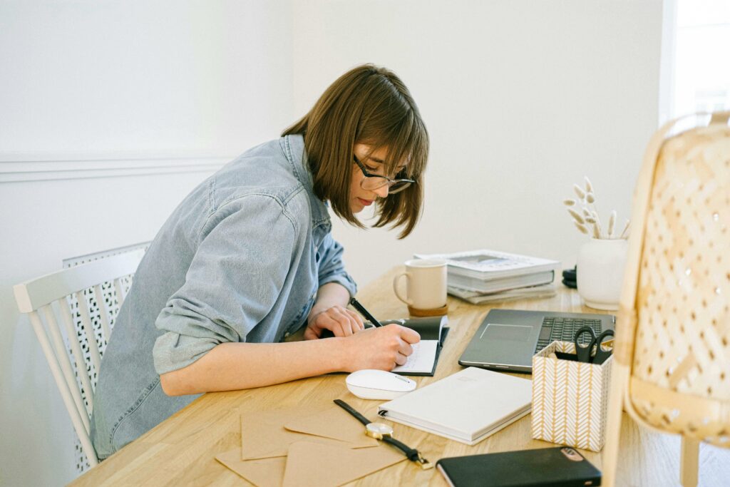 a woman writing on a notebook