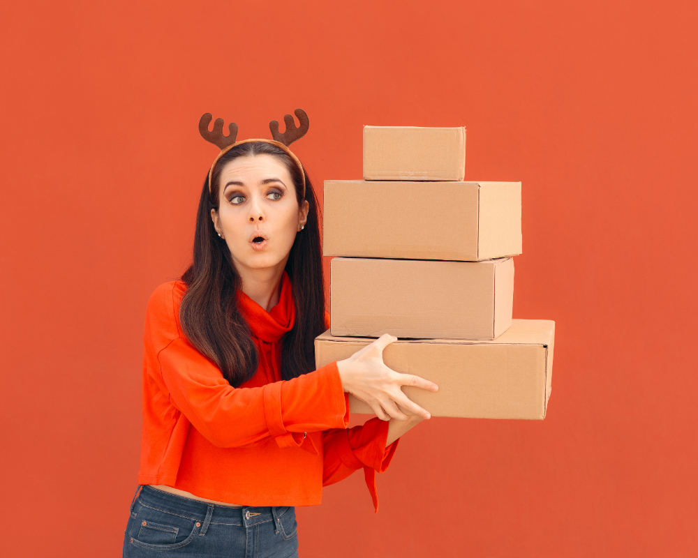 a woman holding a stack of boxes