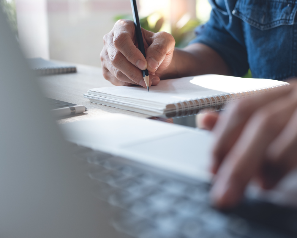 a person writing on a notebook