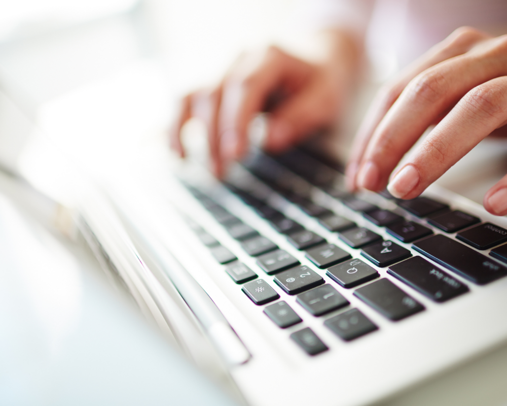 a close-up of a person's hands on a laptop keyboard
