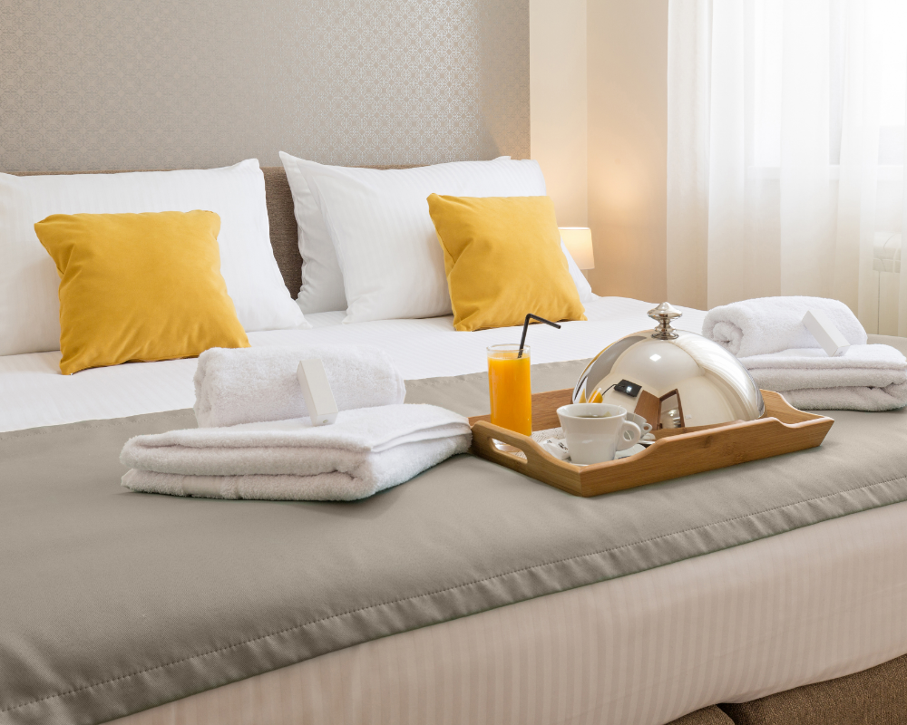 a tray of towels and a tray of tea on a bed