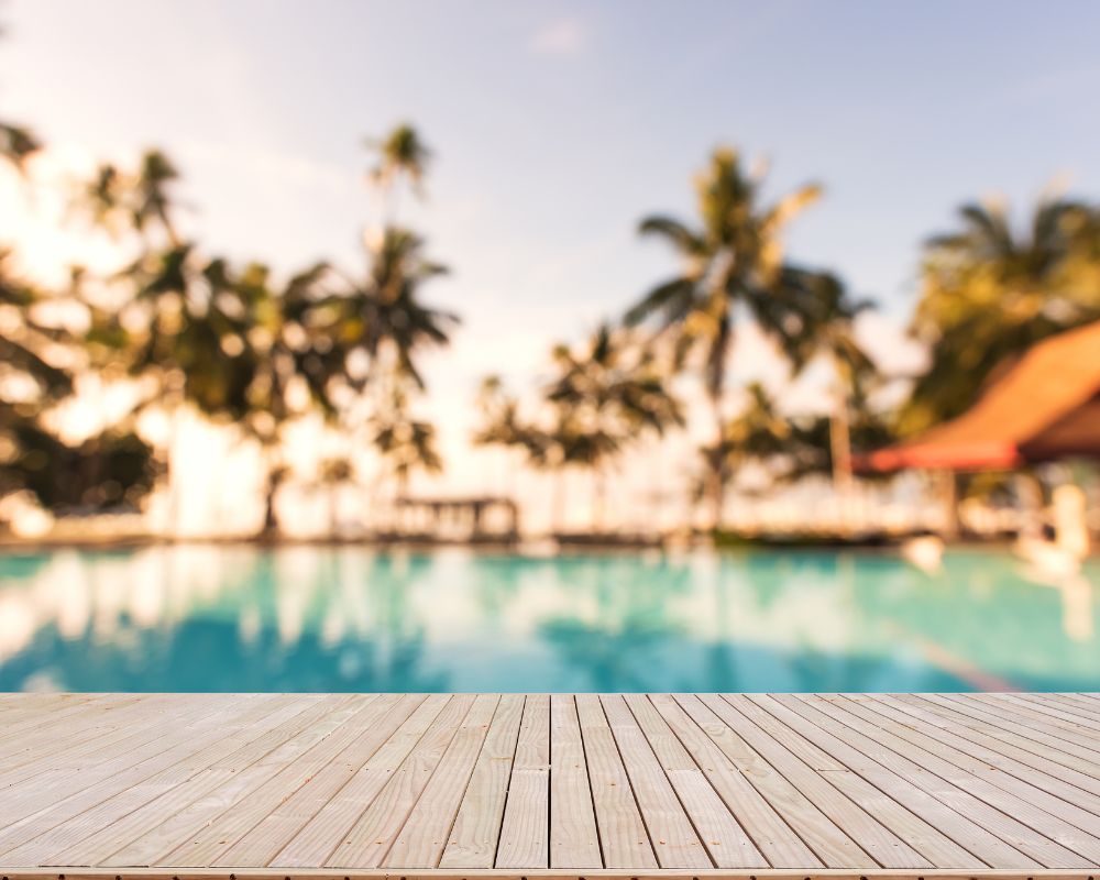 a wooden deck with a pool in the background