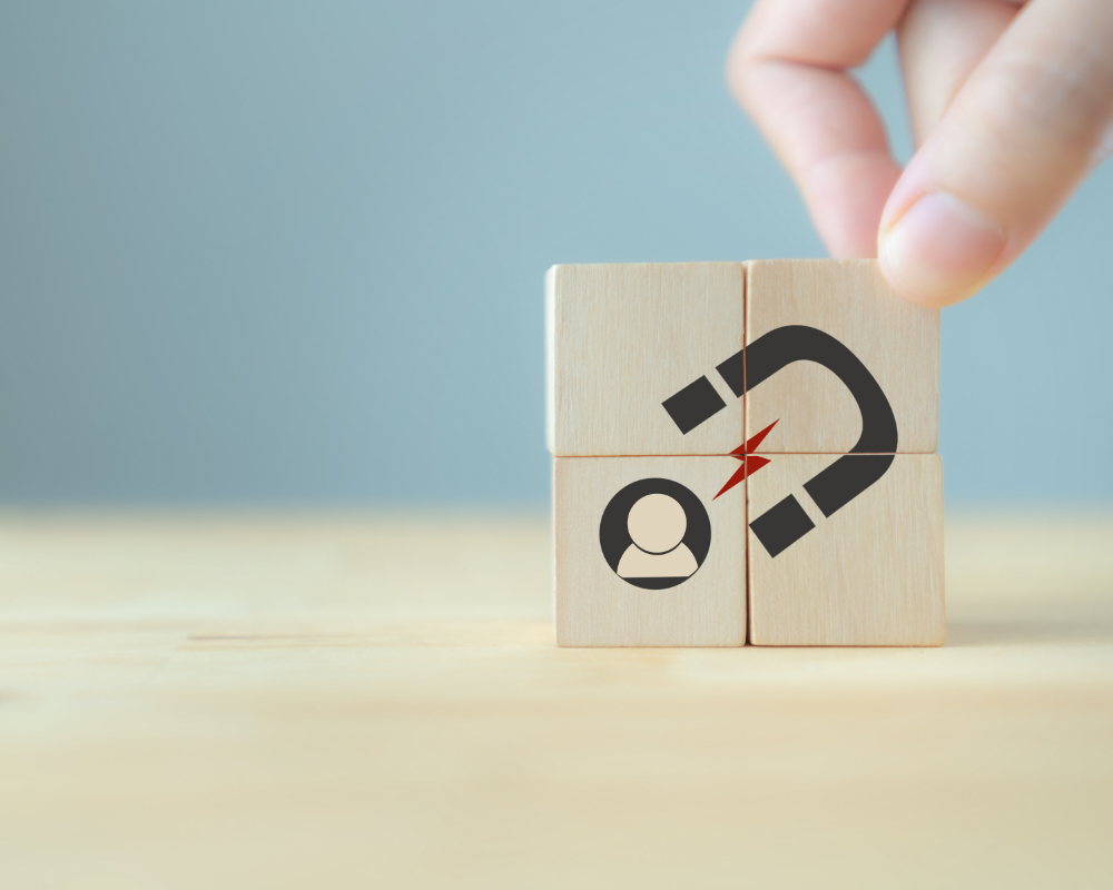 a hand holding a wooden block with a magnet and a person with a red lightning bolt