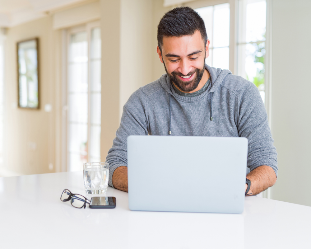a man sitting at a table with a laptop