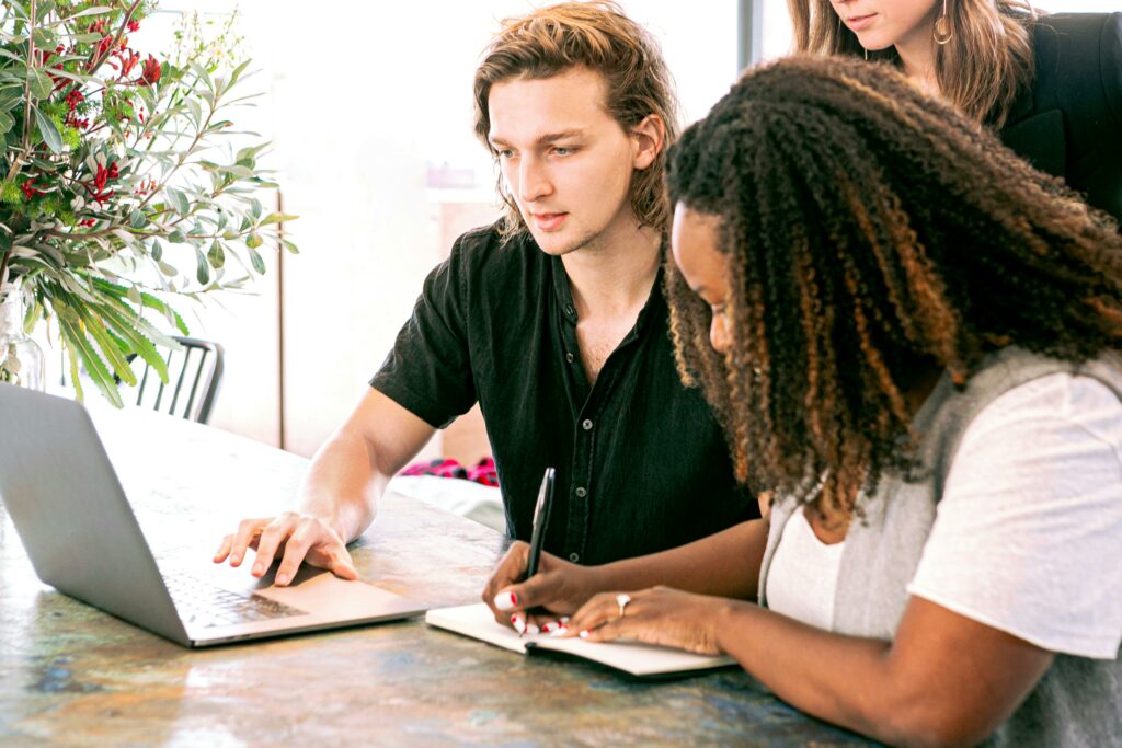a man and woman looking at a laptop